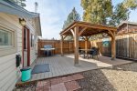 Fenced backyard with barbecue, covered patio outdoor dining for four